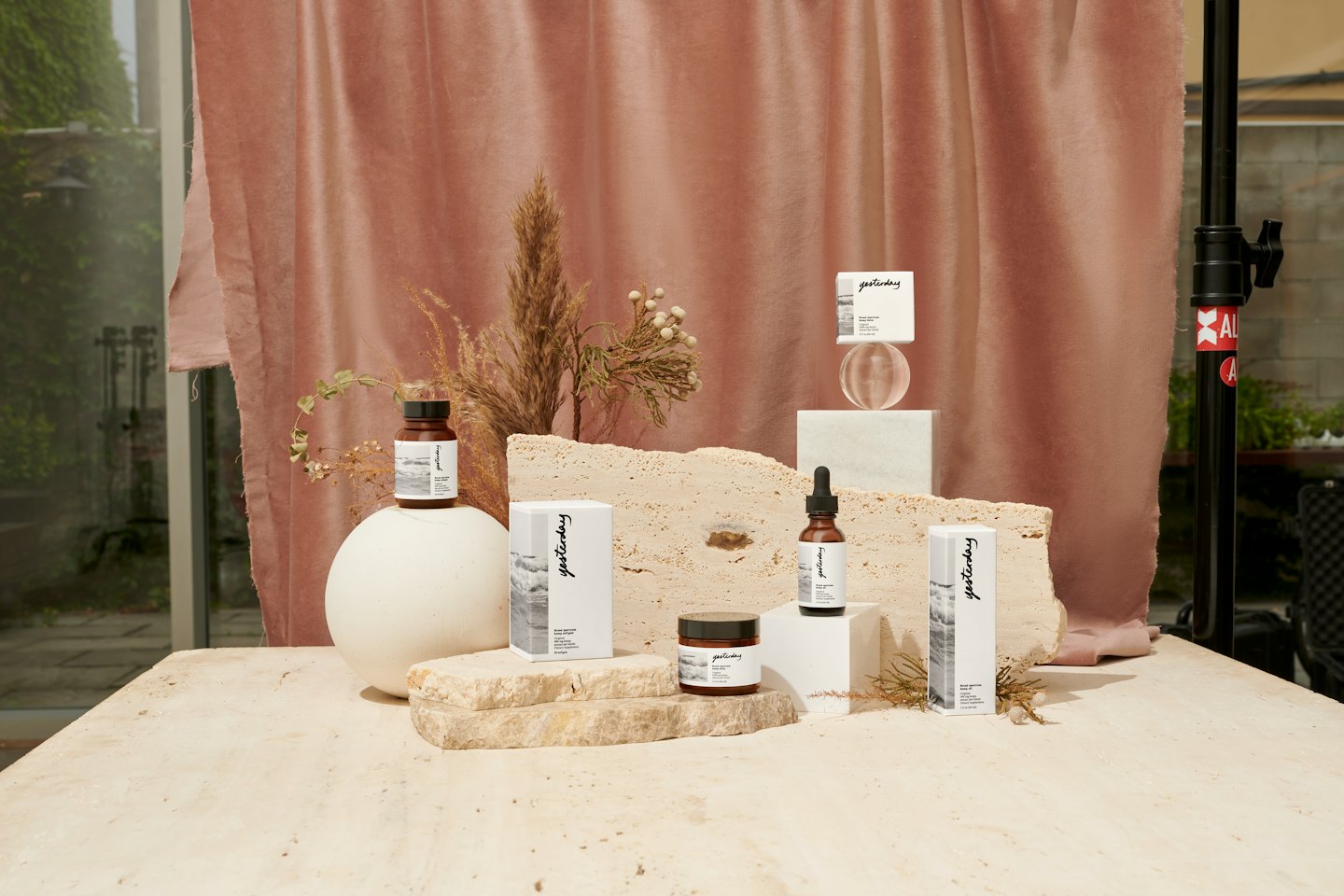Cosmetic products arranged on stone risers and geometric shapes.